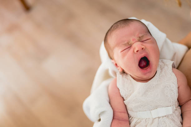 istock Newborn yawning in her mother's arms. 1708615481