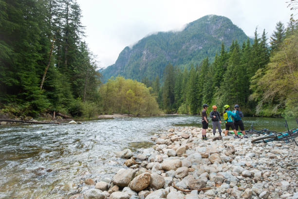 istock Multi-Generation, Multracial Group of Mountain Bikers Exploring Resting at Forested Riverbank 1708646094