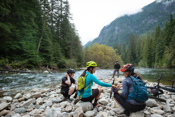 istock Diverse Group of Mountain Bikers Taking Lunch Break at River 1708646104