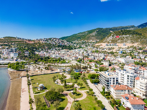 Aerial view of Finike district of Antalya. Buildings, sea, mountains and trees are visible. Morning hours, a summer day. Drone shooting.
