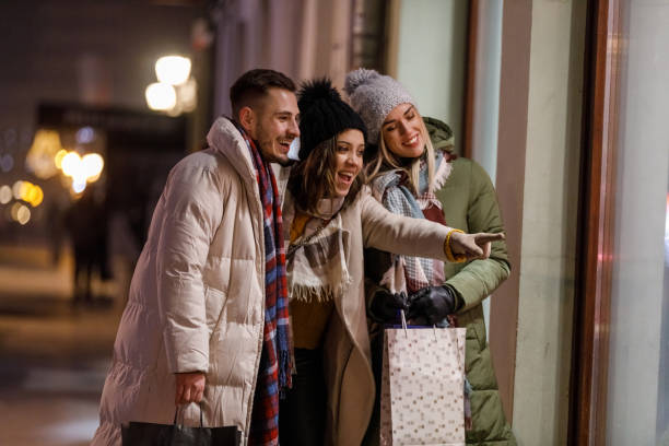 istock Three joyful friends window shopping during Christmas holidays 1708795142