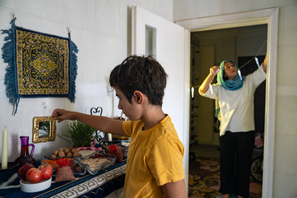 Mother and son decorating home for Nowruz Holiday stock photo