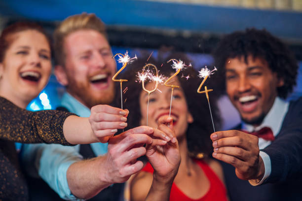 Two couples with sparklers Young happy people looking at sparklers in their hands new years eve stock pictures, royalty-free photos & images