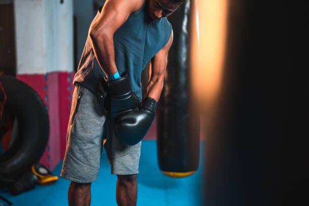 istock Athletic Young Multiracial Male Boxer Taking Off His Gloves 1708804828