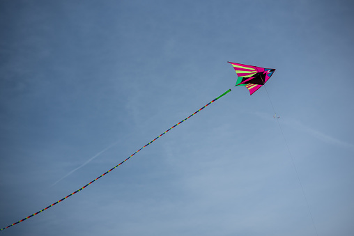 Colorful Asian silk kite flying against the blue sky