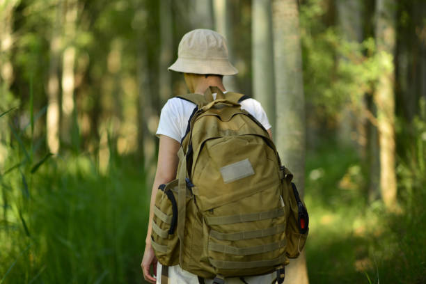 istock Young woman with backpack walking in the forest. 1708832141