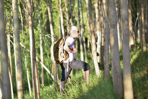 mountaineer traveling in nature, lighting a campfire, hiking, sitting and resting