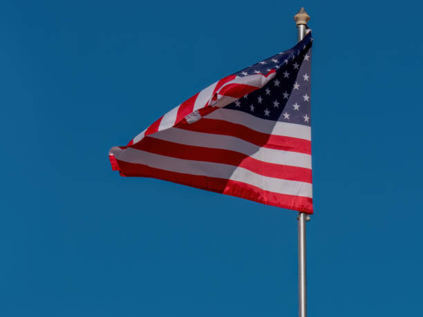 istock American Flag Waving in the Wind Against a Blue Sky 1708858513