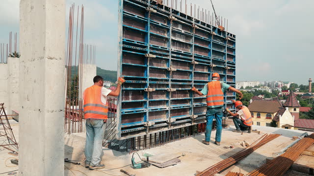 Builders install a large metal structure for pouring monolith. Construction work at the construction site. Work of builders.