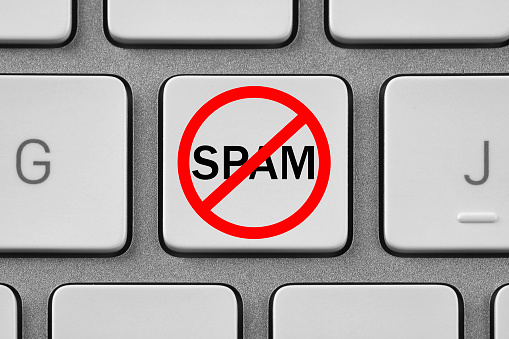 Prohibition sign with word Spam on laptop button, top view. Device keyboard, closeup