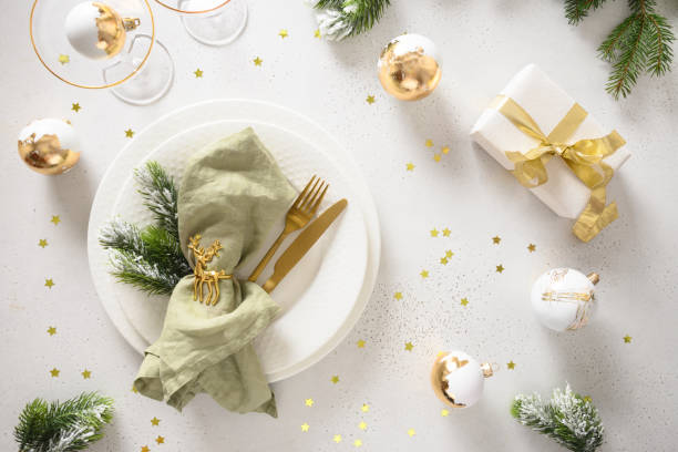 istock Beautiful Christmas festive table setting with white plate, golden balls on white. 1708876747