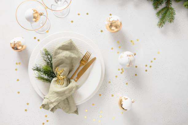 istock Beautiful Christmas festive table setting with white plate, golden balls on white. 1708876749