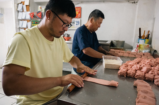The breakfast diner owner and his son are busy kneading dough and preparing ingredients.