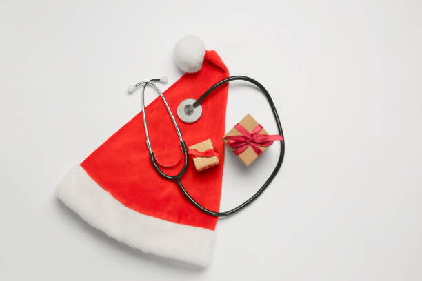 istock Greeting card for doctor with stethoscope, gift boxes and Santa hat on white background, top view. Space for text 1708896639