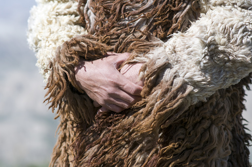 Migrant man in traditional dress in sheepskin