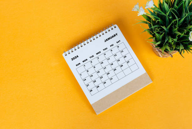 istock January 2024 desk calendar on yellow background. Directly above. Flat lay. 1708932949