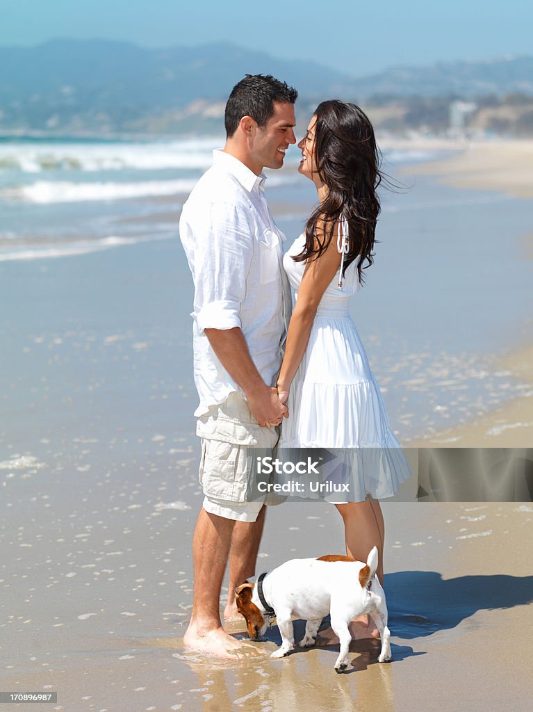 Sonriente Pareja joven romancing en la playa - Foto de stock de Adulto libre de derechos