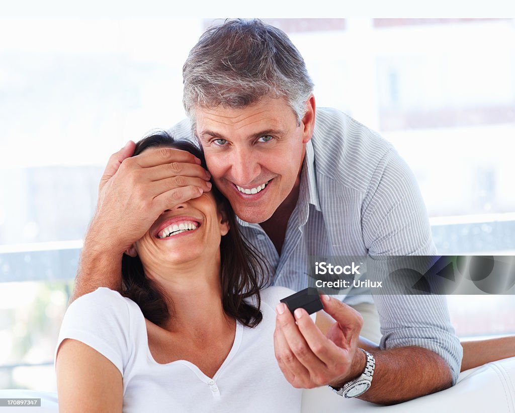 Hombre maduro sobre su esposa para que pueda sorprender a sus ojos - Foto de stock de Adulto libre de derechos