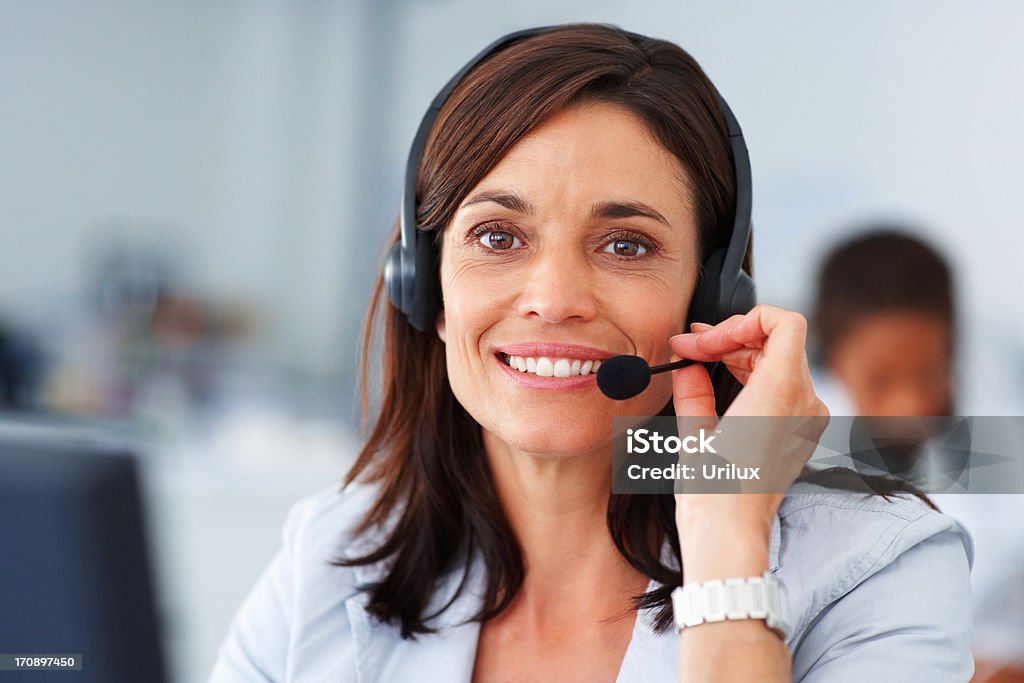 Feliz hermosa operador usando un auricular en un trabajo - Foto de stock de Adulto libre de derechos