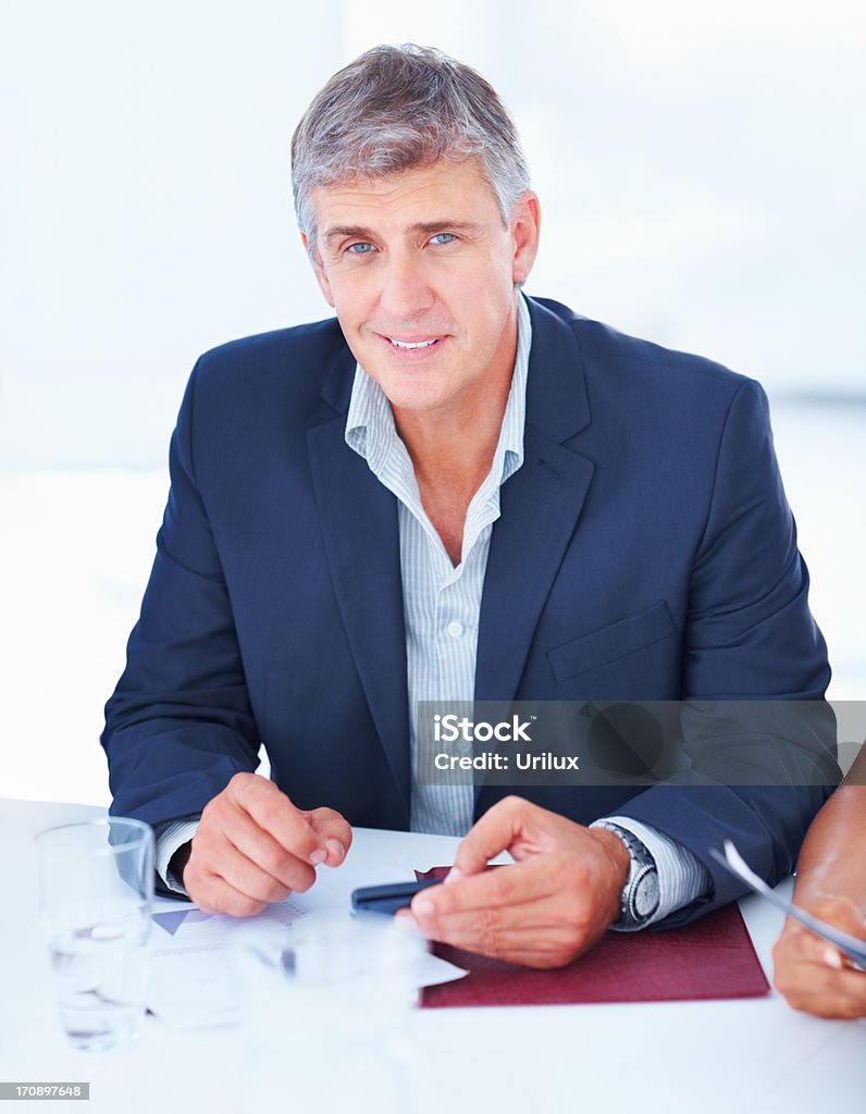 Bell'uomo d'affari di successo maturo seduto su una scrivania - Foto stock royalty-free di Abbigliamento elegante