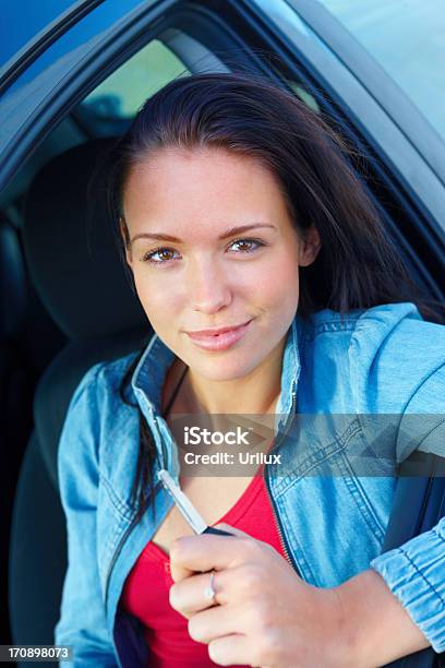 Sorridente Jovem Mulher Sentada Em Um Carro E Segurando A Chave - Fotografias de stock e mais imagens de Adulto