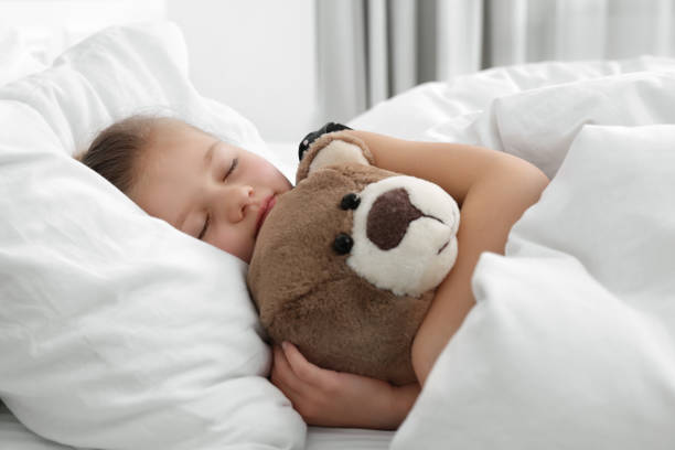 istock Cute little girl sleeping with teddy bear in bed 1708984696