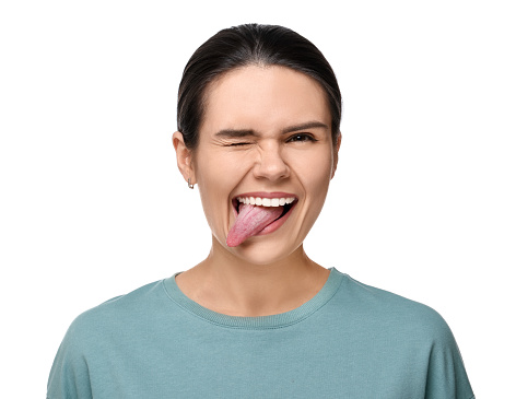 Happy young woman showing her tongue on white background