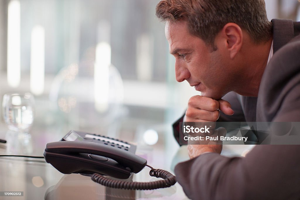 Businessman staring at telephone waiting for it to ring  Waiting Stock Photo