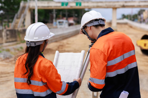 istock Engineer use theodolite equipment and looking blueprints construction project for route surveying to build a bridge 1709048035