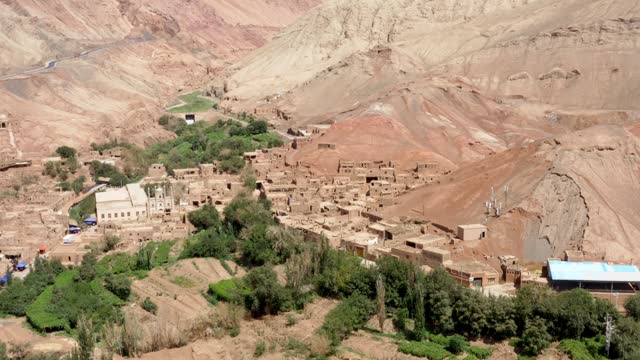 Establishing shot of Tuyoq valley in Xinjiang, Tuyuk aerial of oasis-village in the Taklamakan desert, Flaming Mountains, Xinjiang Uighur, Region of China.