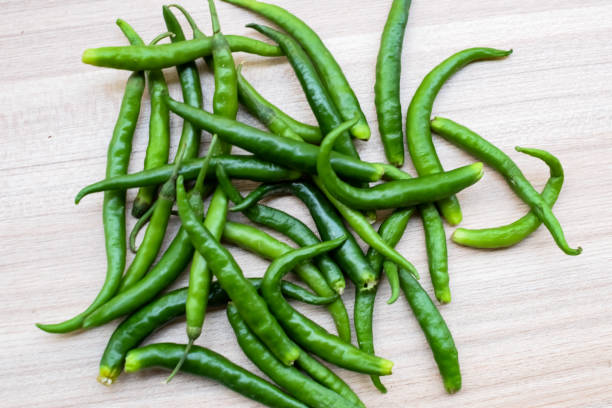istock Fresh Green chili pepper on plain wooden table, green essential vegetables for all essential foods, view of unpeeled vegetables with plain background 1709128243