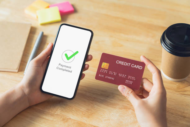 istock Hands holding smartphone with credit card and showing payment completed message on mobile. 1709182565