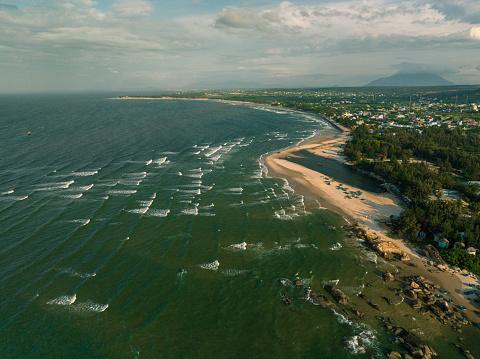 Drone view Ke Ga beach with many waves layers, Binh Thuan province, central Vietnam