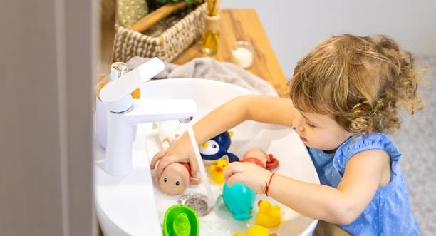 子供はバスルームでおもちゃを洗います。限定フォーカス。 - four animals four objects four people cleanup ストックフォトと画像