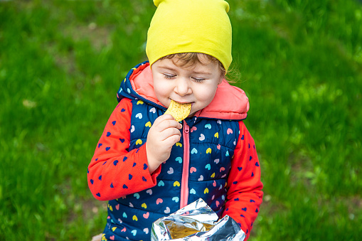 The child eats chips in the park. Selective focus. Nature.