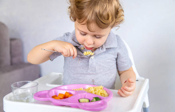 istock The child eats pasta and vegetables. Selective focus. 1709275230