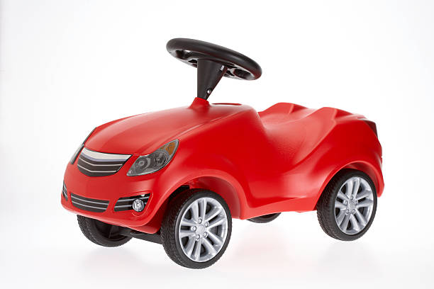 small red toy car side view on white background - speelgoedauto stockfoto's en -beelden