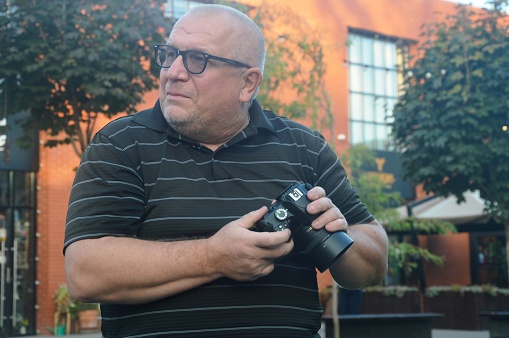 portrait of a reporter photographer with a camera in his hands