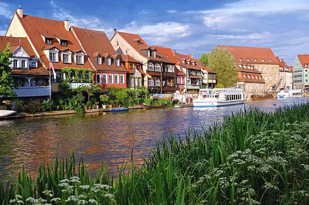 The UNESCO world heritage site of "Klein Venedig ("Little Venice"), the "Alter Hafen"  (Old harbour) in Bamberg and sightseeing boats on the river Regnitz on a late afternoon after a thunderstorm has passed.