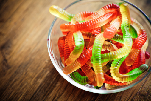 Gummy worms in a translucent bowl.