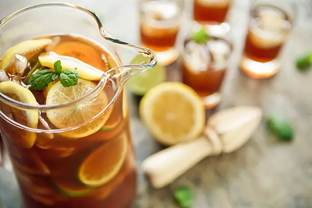 A jug and four glasses of fresh homemade ice tea.