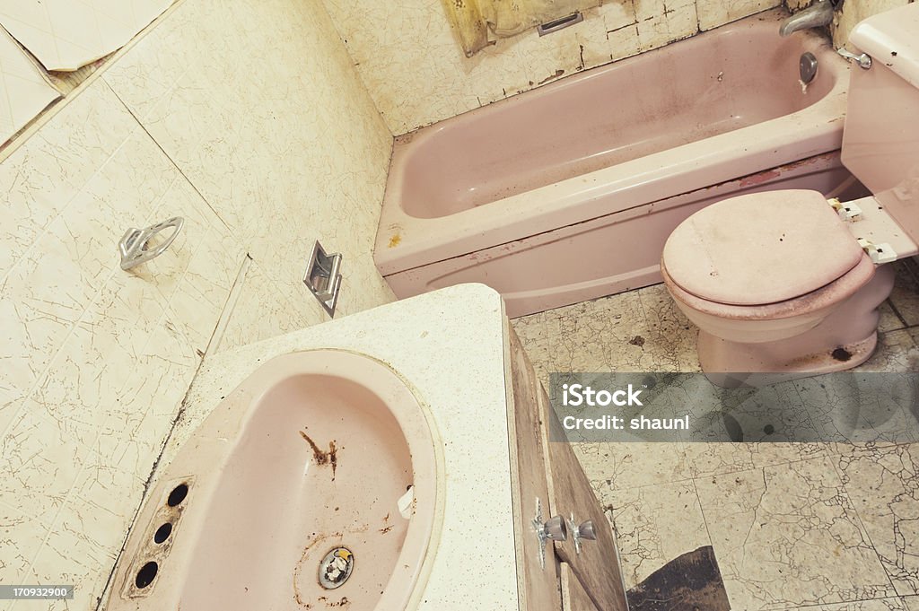 Pretty in Pink A severely neglected bathroom inside an abandoned home. Bathroom Sink Stock Photo