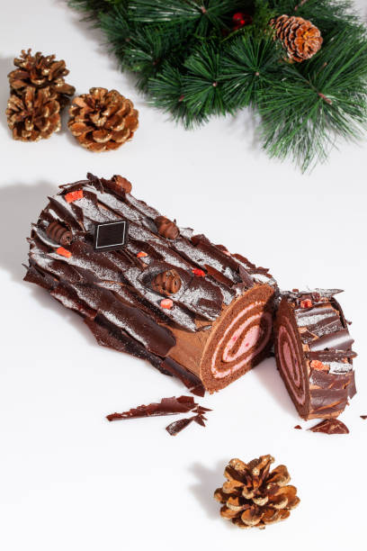 istock Sliced chocolate roll on white background with pine branch and fir cones 1709343622