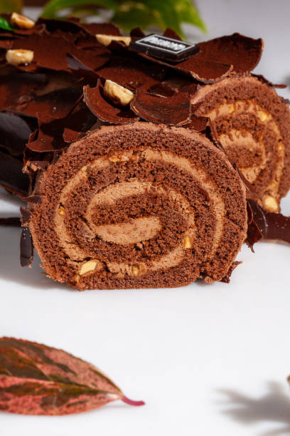 istock Sliced log-shaped chocolate roll with buttercream and hazelnuts 1709343636