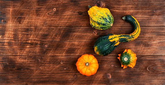 Autumn background with pumpkins on old wooden table, copy space. Autumn harvest concept.