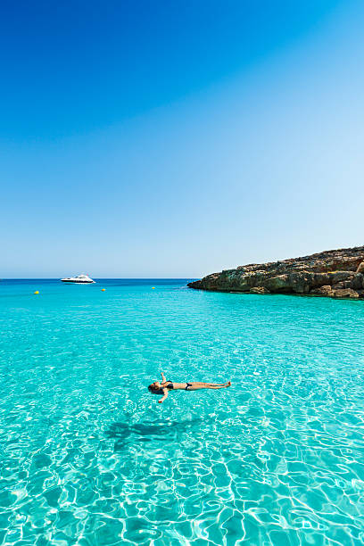 Idyllic and relaxing holidays Idyllic holidays: girl floating in fresh clean turquoise water. minorca photos stock pictures, royalty-free photos & images