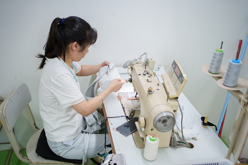 Female sewing worker in garment factory