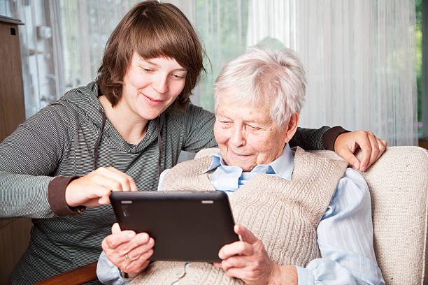 istock senior woman and young using digital tablet 170936970