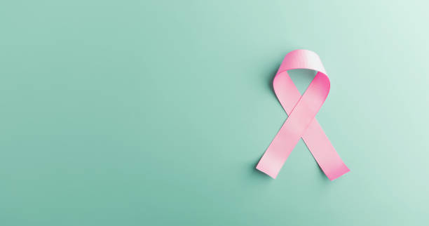 Breast Cancer Awareness Campaign Concept. Women Healthcare. Close up of a Pink Ribbon Lying on light blue background, Top View stock photo