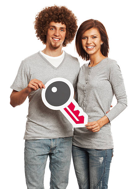istock Smiling young couple holding access key sign isolated on white. 170939264